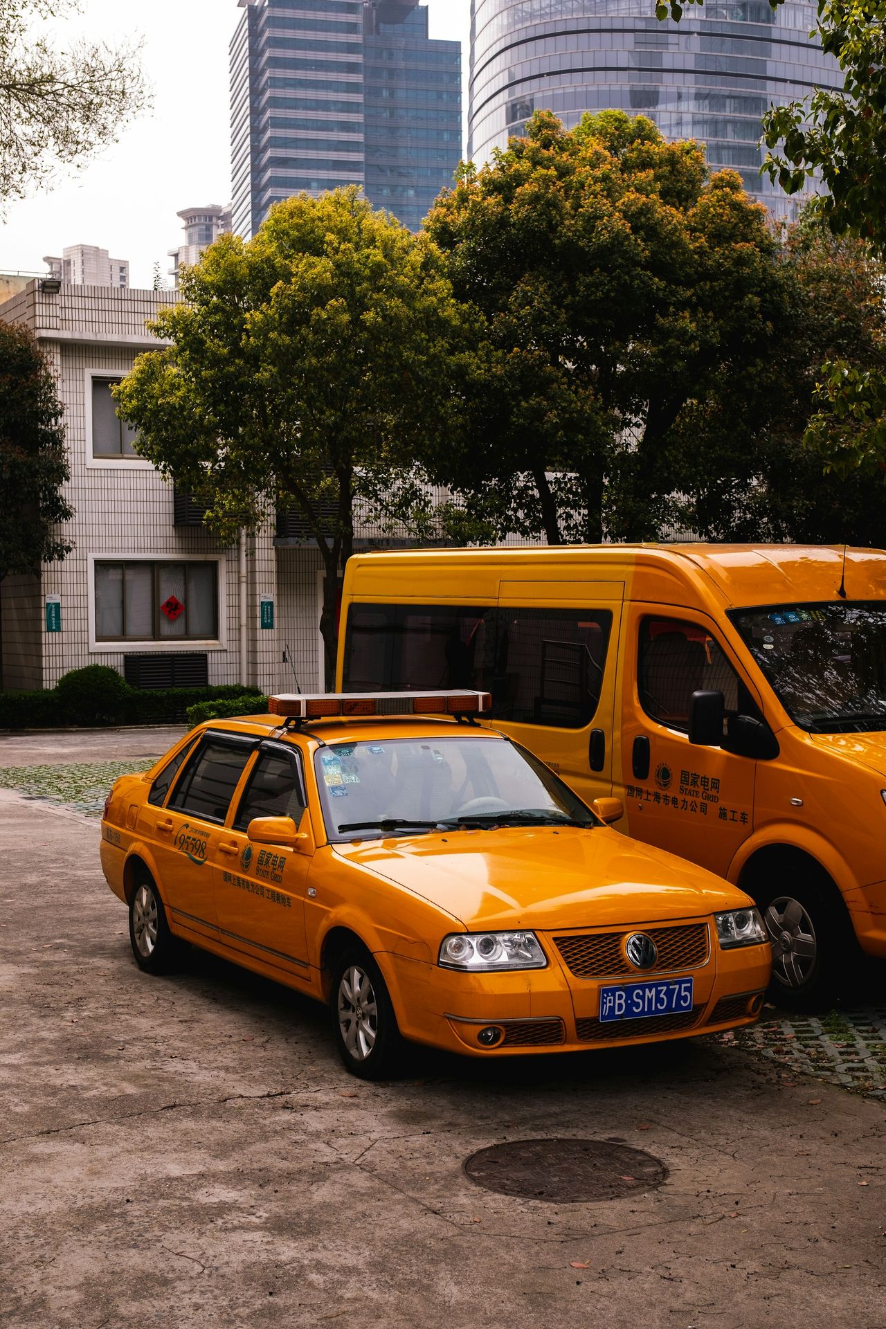 a yellow taxi cab parked next to a yellow bus